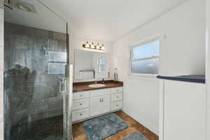 Full bathroom featuring vanity, baseboards, a stall shower, and tile patterned floors