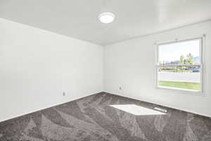 Carpeted spare room with baseboards and visible vents