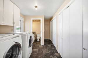 Washroom featuring stone finish floor, baseboards, laundry area, and independent washer and dryer