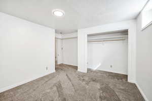 Unfurnished bedroom with baseboards, carpet flooring, and a textured ceiling