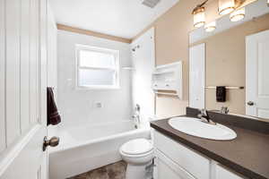 Bathroom featuring visible vents, tile patterned flooring, shower / washtub combination, vanity, and toilet