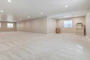 Below grade area with baseboards, light carpet, and recessed lighting