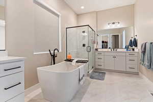 Full bathroom featuring a shower stall, a soaking tub, marble finish floor, and vanity