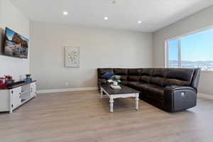 Living room with baseboards, recessed lighting, light wood-style flooring, and a mountain view