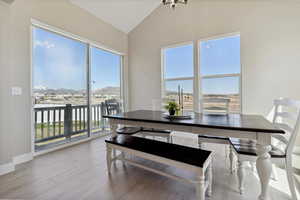 Dining area featuring wood finished floors, lofted ceiling, and a healthy amount of sunlight