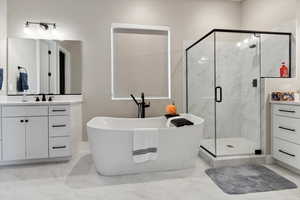 Bathroom featuring a freestanding tub, a marble finish shower, and marble finish floor