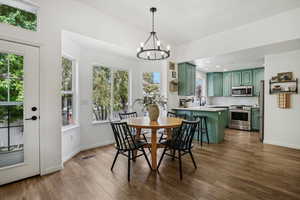 Dining area with a chandelier, plenty of natural light, dark wood finished floors, baseboards, and recessed lighting