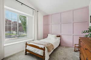Bedroom with multiple windows, light carpet, and lofted ceiling