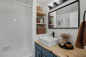Full bathroom featuring shower / bath combination with curtain and vanity