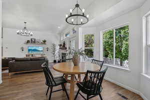 Dining room featuring a chandelier, healthy amount of natural light, wood finished floors, and recessed lighting