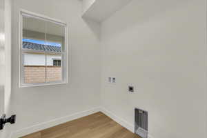 Washroom with laundry area, hookup for a washing machine, baseboards, wood finished floors, and hookup for an electric dryer