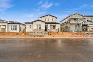 View of front of house featuring stone siding and stucco siding