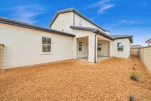 Back of property with a fenced backyard, a patio, and stucco siding