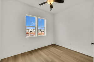 Empty room featuring baseboards, ceiling fan, and light wood-type flooring