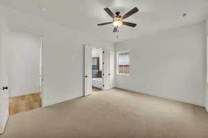 Unfurnished bedroom with baseboards, visible vents, light carpet, and ensuite bathroom
