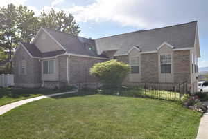 Single story home featuring brick siding, a shingled roof, fence, and a front yard