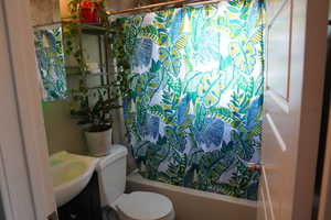 Full bath with toilet, shower / bath combination with curtain, and vanity