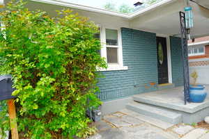 Doorway to property with brick siding and a porch