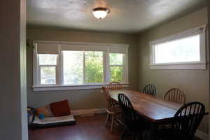 Dining room featuring elegantly trimmed windows and hardwood / wood-style floors