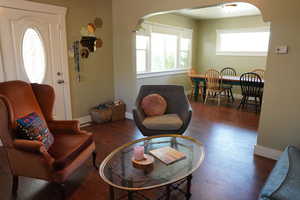 Living area featuring arched walkway, beautiful trimmed baseboards, and wood finished floors