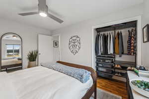 Bedroom featuring a ceiling fan, a closet, and wood finished floors