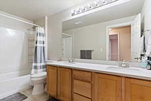 Full bath featuring toilet, tile patterned flooring, visible vents, and a sink