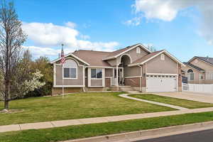 View of front of home featuring stucco siding, a front lawn, brick siding, and driveway