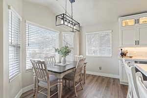 Dining space with baseboards, a wealth of natural light, and wood finished floors
