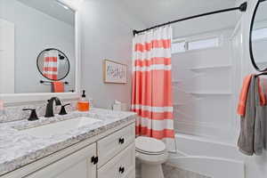Bathroom featuring vanity, shower / bathtub combination with curtain, wood finished floors, and toilet