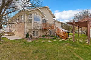 Back of property featuring a yard, stairway, and a deck