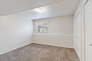 Unfurnished bedroom featuring carpet, baseboards, and a closet