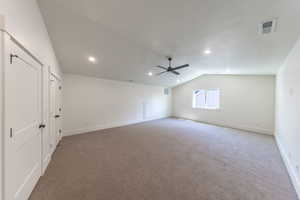 Spare room featuring vaulted ceiling, light colored carpet, recessed lighting, and a ceiling fan