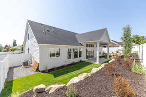 Back of house with roof with shingles, a fenced backyard, a patio area, and a gate