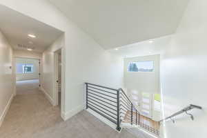 Staircase with carpet floors, plenty of natural light, and recessed lighting