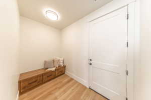 Mudroom with light wood-style flooring and baseboards