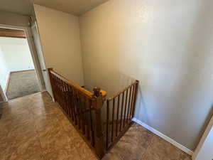 Stairway with a textured wall and baseboards