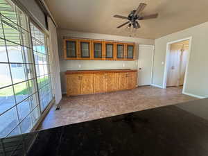 Kitchen with baseboards, glass insert cabinets, visible vents, and brown cabinets