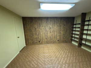 Finished basement featuring baseboards and wooden walls
