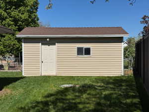 View of outdoor structure with an outbuilding and fence