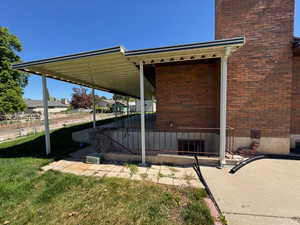 View of home's exterior featuring a yard, a chimney, and brick siding