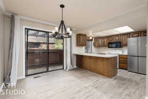 Kitchen with freestanding refrigerator, visible vents, light wood-style flooring, black microwave, and white electric range