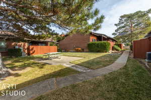 View of yard with central air condition unit, a patio, and fence