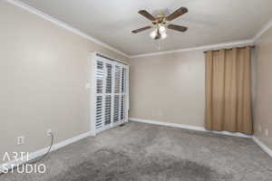 Unfurnished room with a ceiling fan, ornamental molding, carpet flooring, and baseboards