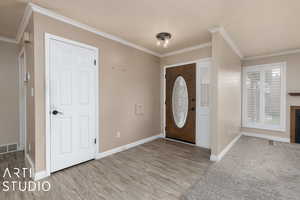 Entryway featuring crown molding, visible vents, and baseboards