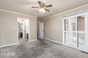 Unfurnished bedroom with crown molding, visible vents, baseboards, and carpet floors