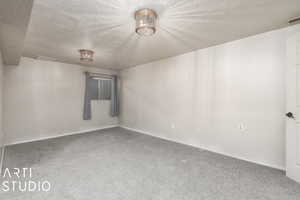 Empty room featuring baseboards, carpet flooring, visible vents, and a textured ceiling