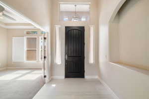 Entryway with a towering ceiling, baseboards, and a healthy amount of sunlight