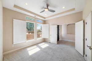 Unfurnished bedroom featuring recessed lighting, baseboards, visible vents, a raised ceiling, and light carpet