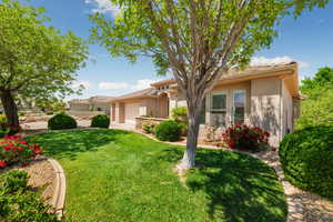 View of front of property featuring driveway, a tile roof, a garage, stucco siding, and a front lawn
