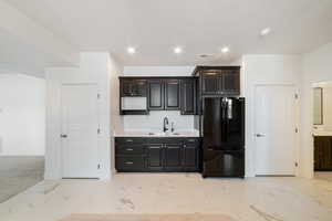 Kitchen with a sink, freestanding refrigerator, visible vents, light countertops, and marble finish floor